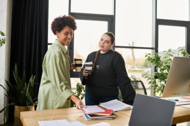 Modern bir ofis ortamında iki kadın ortak bir tartışmaya giriyorlar..