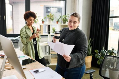 İki profesyonel kadın takım çalışması yapıyor, parlak bir ofis ortamında fikir ve planlarını paylaşıyorlar..