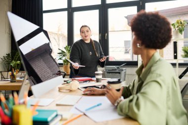 İki dinamik bayan yönetici aktif olarak modern bir işyeri ortamında çalışırlar..