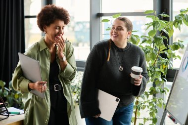 Modern bir çalışma alanında beyin fırtınası yaparken iki dinamik kadın canlı bir sohbete girişiyor..