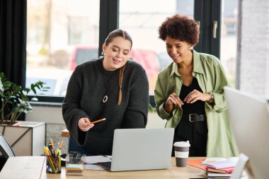 İki kadın yönetici şık bir ofis çalışma alanında ortak bir tartışmaya giriştiler..