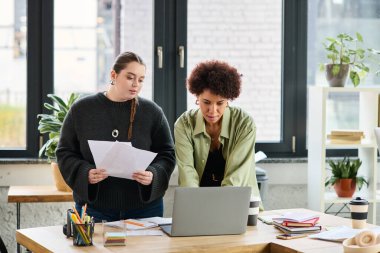 İki genç bayan yönetici modern bir ofiste verimli bir takım çalışmasına giriştiler..