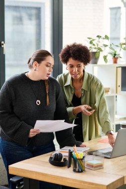 İki genç kadın bir ofiste evrakları incelerken verimli bir tartışma içindeler..