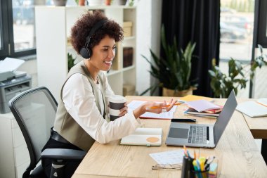 Genç bir Afrikalı Amerikalı iş kadını kahve içerken iş arkadaşlarıyla fikirlerini paylaşıyor..