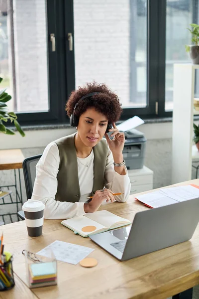 Genç işletme yöneticisi ofiste sanal bir toplantıya katılırken görevlere odaklanıyor.