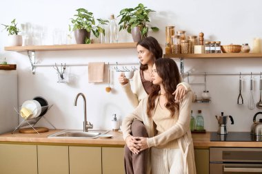 İkiz kardeşler büyüleyici, yeşil bir mutfakta birlikte rahatlar..