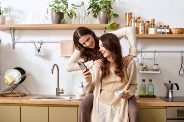 İkiz kardeşler sıcaklık ve neşe dolu aydınlık bir mutfakta birlikte kaliteli vakit geçirmenin tadını çıkarırlar..