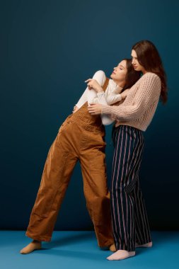 İki genç ve güzel ikiz kardeş, benzersiz tarzlarını ve bağlarını sergileyerek neşeli bir anı paylaşıyorlar..