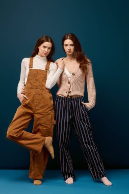 İki genç ikiz kardeş mutlu bir şekilde rahat kıyafetler içinde, neşe ve sıcaklıkla parlıyorlar..