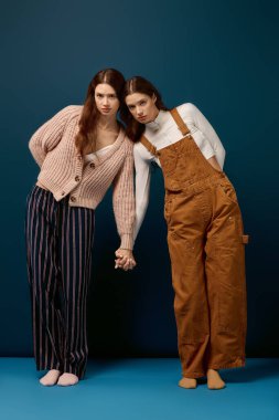 Genç ikiz kardeşler birlikte uyum içinde poz verirken eşsiz tarzlarını sergilerler..