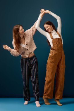 İki genç kız kardeş neşeyle dans eder, kahkaha ve bağlantı dolu bir anda dönerler..