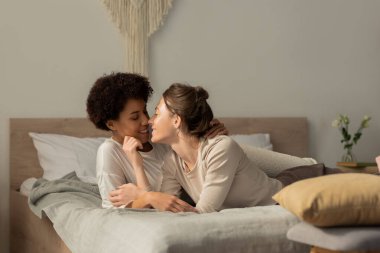 İki kadın aynı şefkatli kucaklaşmayı ve tatlı öpücükleri huzurlu bir yatak odasında paylaşıyor, mutluluk saçıyor..