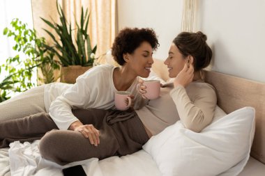 İki kadın sıcak bir odada birbirine eşlik etmekten zevk alır. Gülüşleri ve sıcak içkileri paylaşırlar..