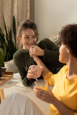 İki kadın sıcacık bir yerde sarılıp, kahkahaları ve sıcaklığı içki içerken paylaşıyor, sevgi saçıyor..