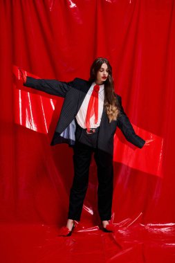 Genç bir kadın şık bir takım elbiseyle eşsiz tarzını sergiliyor. Kendine güveni tam..