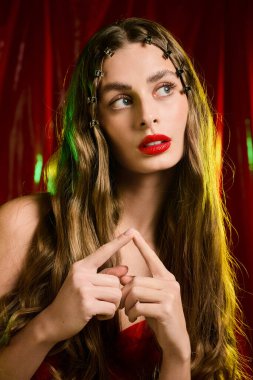 Dalgalı saçları olan güzel genç bir kadın zarif ve çekici bir görünüm sergiliyor..