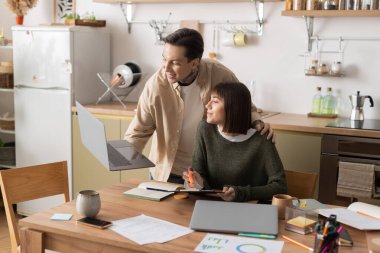 Sevgi dolu bir çift, rahat masalarında çalışırken keyifli bir anı paylaşır..