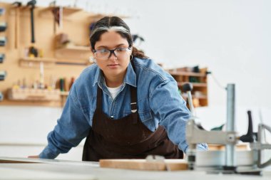 Genç ve güzel bir kadın, canlı bir atölyedeki işine dikkatle odaklanır..