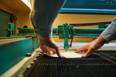 Genç ve güzel bir kadın, canlı bir atölyede, odaklanmış ve meşgul bir projede ustalıkla çalışıyor..