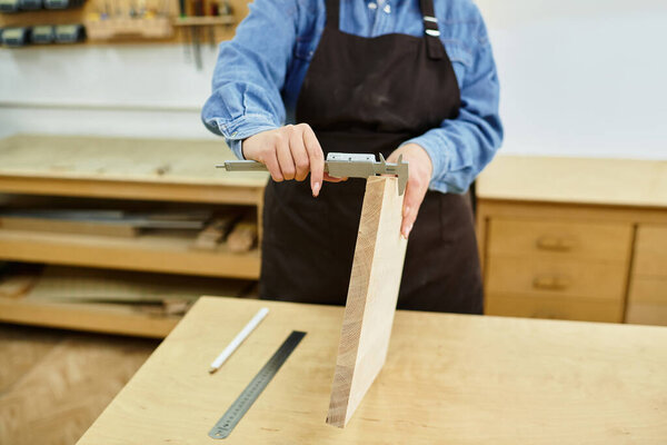 A skilled young woman focuses intently on measuring wood during a hands on crafting workshop.