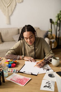 Parlak bir dairede, genç bir Afrikalı Amerikalı kadın yaratıcılığını sanatla ifade ediyor..