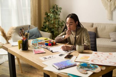 Örgülü genç bir Afrikalı Amerikalı kadın kendini sanatsal eserlere kaptırdı..