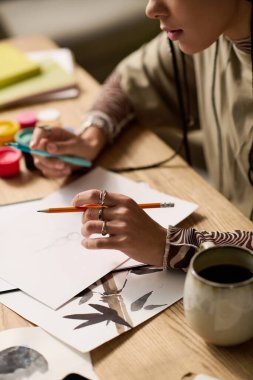 Genç bir siyahi kadın, evde sanat eserleri arasında tutkuyla çizim yapıyor..