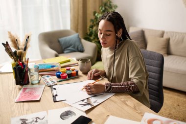 Genç bir Afrikalı Amerikalı kadın ışık dolu şık dairesinde güzel sanatlar yaratıyor..