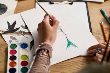 Örgülü genç bir kadın şık dairesinde resim yapmaya daldı..