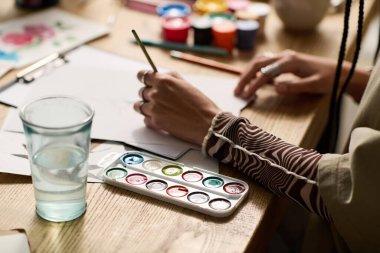 Genç bir kadın resim yaparken yaratıcılığını modern dairesinde gösteriyor..