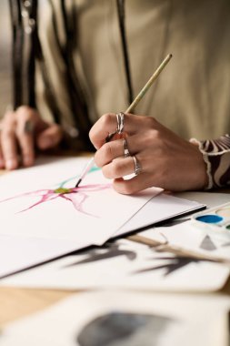 Genç bir kadın modern dairesinde resim yapmaktan hoşlanıyor, yeteneğini sergiliyor..