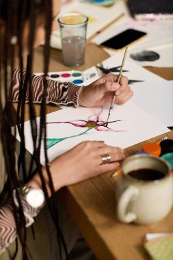 Genç bir Afrikalı Amerikalı kadın evinde özenle resim yapıyor, yaratıcılığını kucaklıyor..