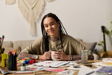 Örgülü genç bir Afrikalı Amerikalı kadın sanatının keyfini çıkarırken modern dairesinde dinleniyor..