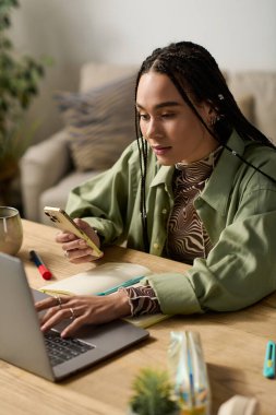 Samimi bir dairede, örgülü genç bir Afrikalı Amerikalı kadın telefonu ve laptopuyla meşgul oluyor..