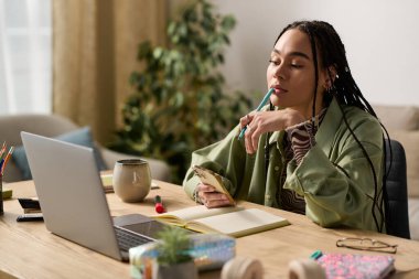 Genç bir Afrikalı Amerikalı kadın, şık dairesinde düşünceli bir şekilde oturur ve fikirlerini yazar..