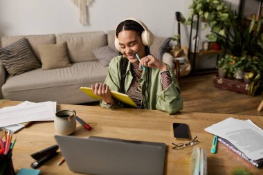 Süslü saçları olan genç bir Afrikalı Amerikalı kadın etrafı şık dekorlarıyla çevriliyken ders çalışmaktan zevk alıyor..