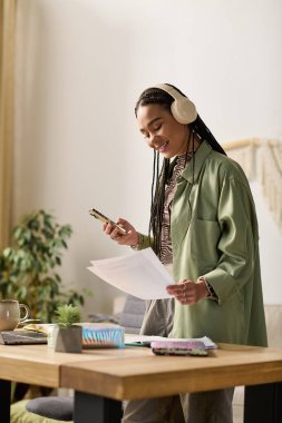 Genç bir kadın modern dairesinde hayat dolu bir hayat ve yaratıcılıktan zevk alıyor. Çalışırken gülümsüyor..