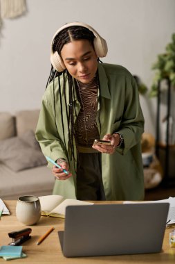 Modern bir dairede, örgülü genç siyahi bir kadın görevlerine keyifle odaklanır..