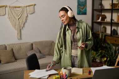 Örgülü şık bir genç kadın modern dairesinden zevk alırken aynı zamanda çalışıyor ve fikirler yaratıyor..