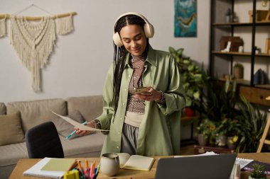 Modern bir dairede, örgülü genç siyah bir kadın telefonunu kontrol eder ve çok çalışır..