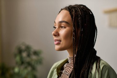 Süslü saçları olan genç bir Afrikalı Amerikalı kadın, şık apartman hayatının tadını çıkarıyor..