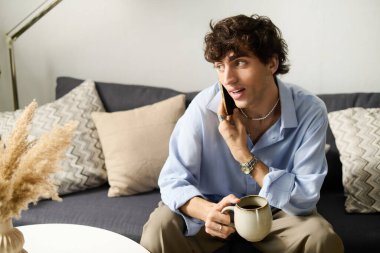 Evde dinlenirken telefonda konuşan kıvırcık saçlı yakışıklı bir genç..