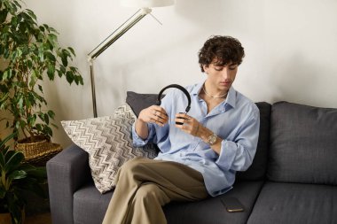 Kıvırcık saçlı yakışıklı genç bir adam modern dairesinde bir anlık mutluluğun tadını çıkarıyor..