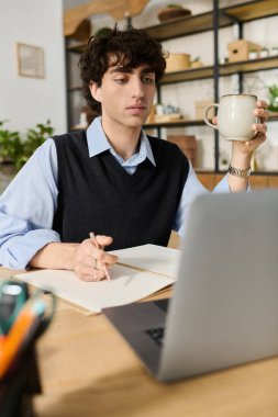 Mavi gömlekli kıvırcık saçlı genç adam elinde kahve fincanı tutarken işe girişiyor..