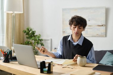 Şık bir genç adam, sakin bir şekilde modern dairesinde otururken notlarına odaklanır..