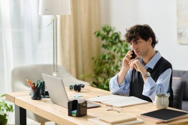 Yakışıklı genç bir adam ahşap bir masada oturuyor. Etrafı modern dekorlarla çevriliyken telefonla konuşuyor..