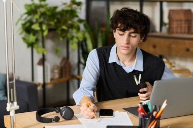 Kıvırcık saçlı yakışıklı genç bir adam şık, bitkilerle dolu bir dairede çalışıyor..