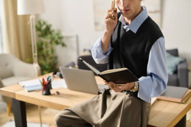 Genç bir adam şık dairesinde bir telefon konuşmasında defter okuyor..