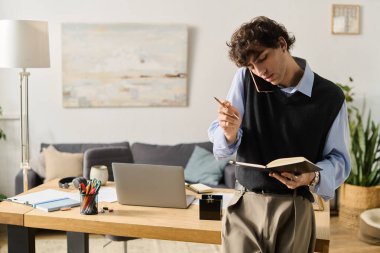 Mavi gömlekli yakışıklı bir genç adam evdeki defterine yazarken düşünceli bir şekilde yansıtıyor..