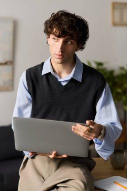 Kıvırcık saçlı yakışıklı bir genç evinde dizüstü bilgisayarını kullanırken derin düşüncelere dalmış..